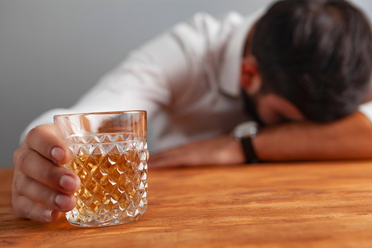 Muž drží pohár alkoholu.